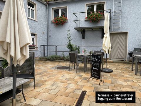 Entree en terras.jpg Terrasse mit rotgelbem Pflaster, Tischen und Stühlen, Sonnenschirmen und Fenstern mit BlumenkästenTerrace with red and yellow paving, tables and chairs, parasols and windows with flower boxesTerasa s červenou a žlutou dlažbou, stoly a židlemi, slunečníky a okny s květinovými truhlíky.Terras met rode en gele bestrating, tafels en stoelen, parasols en ramen met bloembakken