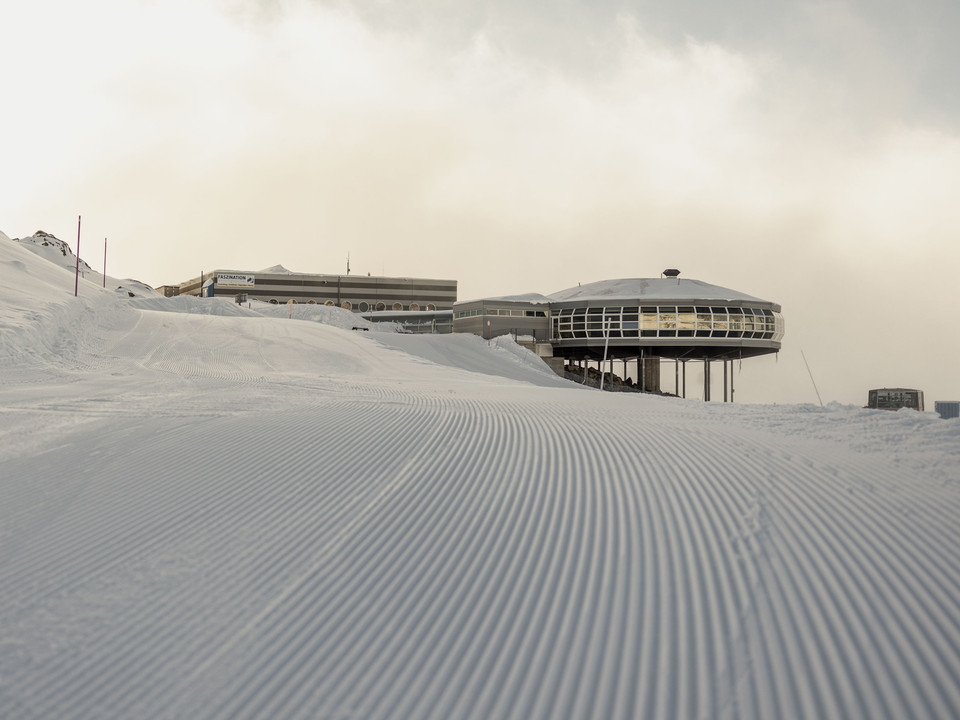 Premières traces dans la neige au Bettmerhorn First Track Bettmerhorn mit frisch präparierter Skipiste bei Morgendämmerung und Blick auf die BergstationFirst Track Bettmerhorn with freshly groomed ski slope at dawn and view of the mountain stationFirst Track Bettmerhorn avec piste de ski fraîchement préparée à l'aube et vue sur la station supérieure