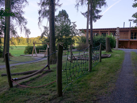 Walderlebniszentrum-Leupoldishain-Koenigstein TVSSW-Yvonne-Brueckner-CCBY (4)web.jpg Holzhaus mit Spielplatz in einem bewaldeten Park.Wooden house with playground in a wooded park.Dřevěný domek s dětským hřištěm v lesoparku.Drewniany dom z placem zabaw w zalesionym parku.Houten huis met speeltuin in een bosrijk park.Casa di legno con parco giochi in un parco alberato.