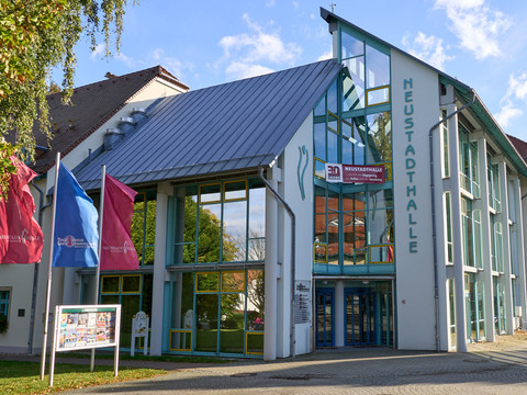 Moderne Glasfassade der Neustadthalle mit blauem Dach und Fahnen.Modern glass façade of the Neustadthalle with blue roof and flags.Moderní skleněná fasáda Neustadthalle s modrou střechou a vlajkami.Nowoczesna szklana fasada Neustadthalle z niebieskim dachem i flagami.Moderne glazen gevel van de Neustadthalle met blauw dak en vlaggen.Moderna facciata in vetro della Neustadthalle con tetto blu e bandiere.