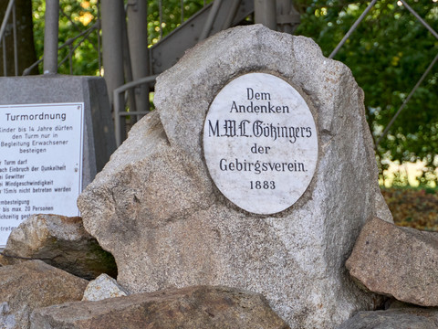 Gedenkstein mit Inschrift "Dem Andenken M.H.C. Götzingers der Gebirgsverein 1883" neben Steintafel "Turmordnung".