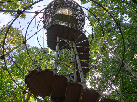 Spiralförmige Aussichtsplattform umgeben von grünen Bäumen.