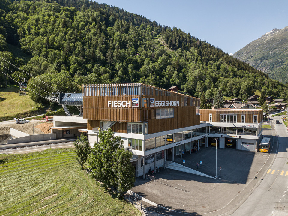Fiesch public transport hub in summer Die Mehrfahrt Aletsch Arena startet am modernen ÖV-Hub Fiesch, wo Bahn, Bus und Gondelbahn perfekt miteinander verbunden sindThe Aletsch Arena multi-journey starts at the modern Fiesch public transport hub, where the train, bus and gondola lift are perfectly interconnectedLe trajet multiple Aletsch Arena débute à la gare centrale moderne des transports publics de Fiesch, où le train, le bus et la télécabine sont parfaitement reliés entre eux.