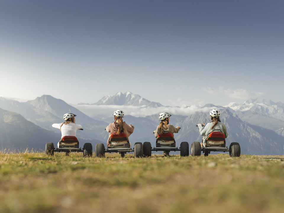 Mountaincart mit Alpenpanorama auf der Riederalp Vier Fahrer geniessen das Panorama der Walliser Alpen und das Erlebnis Mountaincart Aletsch Arena oberhalb der Riederalp an einem klaren SommertagFour riders enjoy the panorama of the Valais Alps and the Aletsch Arena mountain cart experience above Riederalp on a clear summer's dayQuatre conducteurs profitent du panorama des Alpes valaisannes et de l'expérience du Mountaincart Aletsch Arena au-dessus de Riederalp par une claire journée d'été.