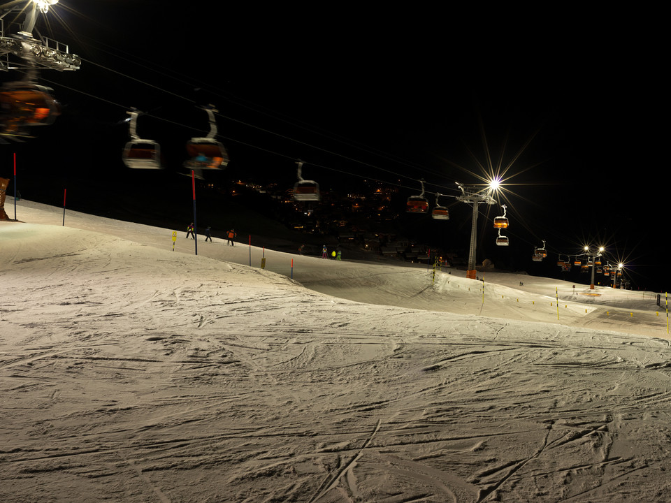 Sessellift beim Nachtskifahren auf der Bettmeralp Beim Nachtskifahren Bettmeralp Riederalp gleiten Skifahrer unter den Lichtern des Sessellifts über die frisch präparierte Piste der Aletsch ArenaAt night skiing Bettmeralp Riederalp, skiers glide under the lights of the chairlift over the freshly groomed slopes of the Aletsch ArenaLors du ski nocturne Bettmeralp Riederalp, les skieurs glissent sur la piste fraîchement préparée de l'Aletsch Arena sous les lumières du télésiège.