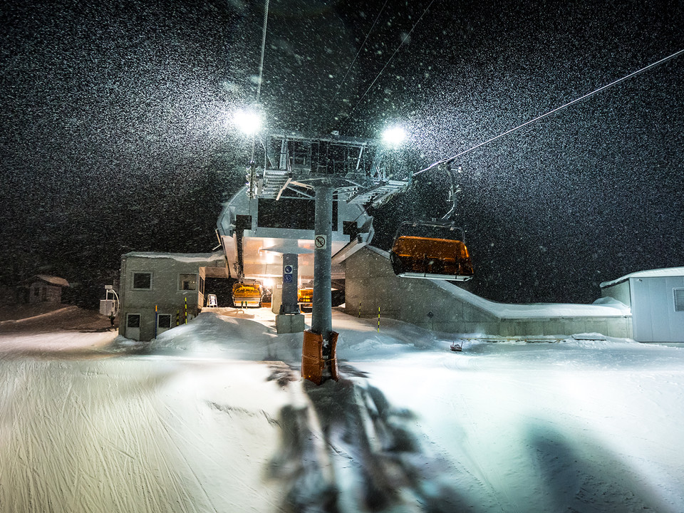 Snowfall and mood lighting for night skiing Während des Nachtskifahren Bettmeralp Riederalp fällt dichter Schnee an der Mittelstation der Sesselbahn in der Aletsch Arena und glitzert im Licht der LampenDuring night skiing in Bettmeralp Riederalp, thick snow falls at the middle station of the chairlift in the Aletsch Arena and glistens in the light of the lampsPendant le ski nocturne Bettmeralp Riederalp, la neige tombe en abondance à la station intermédiaire du télésiège de l'Aletsch Arena et scintille à la lumière des lampes.