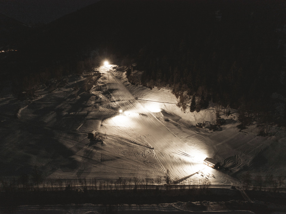 Le ski nocturne à Fieschertal vu du ciel Das Nachtskifahren Fieschertal zeigt aus der Luft beleuchtete Skipisten und Schneeflächen unter klarem Himmel in der winterlichen Aletsch ArenaNight skiing in Fieschertal shows ski slopes and snow surfaces illuminated from the air under a clear sky in the wintry Aletsch ArenaLe ski nocturne de Fieschertal montre des pistes de ski et des surfaces enneigées éclairées par les airs sous un ciel clair dans l'Aletsch Arena hivernale.