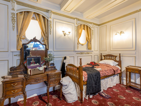 Passagierzimmer - Titanic: Eine Immersive Reise Foto eines nachgebauten Passagierzimmers auf der Titanic mit Schminktisch, Bett und Nachttisch in der Ausstellung "Titanic: Eine Immersive Reise"