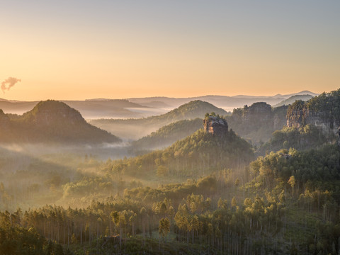 Blick zum Winterstein Morgendämmerung über nebelbedeckten, bewaldeten Hügeln und Felsen.Dawn over mist-covered, wooded hills and rocks.Svítání nad mlhou zahalenými zalesněnými kopci a skalami.Świt nad pokrytymi mgłą, zalesionymi wzgórzami i skałami.Dageraad over met mist bedekte, beboste heuvels en rotsen.L'alba su colline e rocce boscose coperte di nebbia.