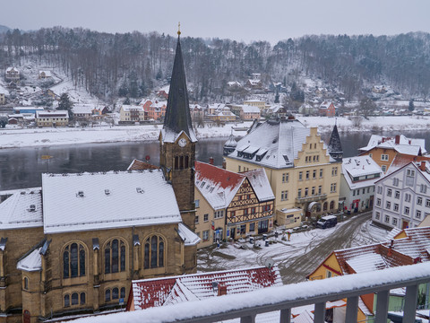 Blick auf Wehlen von Burg Verschneite Stadtansicht mit Kirche, Fluss und Häusern im Winter.Snow-covered town view with church, river and houses in winter.Zasněžený pohled na město s kostelem, řekou a domy v zimě.Pokryty śniegiem widok miasta z kościołem, rzeką i domami w zimie.Besneeuwd stadsgezicht met kerk, rivier en huizen in de winter.Vista della città innevata con chiesa, fiume e case in inverno.