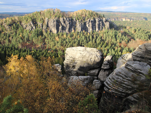Aussicht vom Kleinen zum Großen Bärenstein Felsformationen und Wald im Herbst mit Blick auf ein Tal.Rock formations and forest in the fall with a view of a valley.Skalní útvary a les na podzim s výhledem do údolí.Formacje skalne i las jesienią z widokiem na dolinę.Rotsformaties en bos in de herfst met uitzicht op een vallei.Formazioni rocciose e foresta in autunno con vista su una valle.