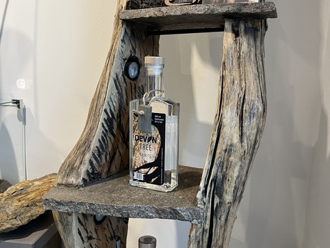 Devona Shop Das Bild zeigt eine stilvolle Präsentation von Devona Spirituosen auf einem rustikalen Holzregal.
