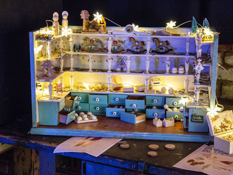 Eine festlich beleuchtete Miniatur-Bäckerei mit detailreichen, winterlichen Dekorationen.A festively illuminated miniature bakery with detailed winter decorations.Svátečně osvětlená miniaturní pekárna s detailními zimními dekoracemi.Świątecznie oświetlona miniaturowa piekarnia ze szczegółowymi dekoracjami zimowymi.Een feestelijk verlichte miniatuurbakkerij met gedetailleerde winterdecoraties.Una pasticceria in miniatura illuminata a festa con decorazioni invernali dettagliate.
