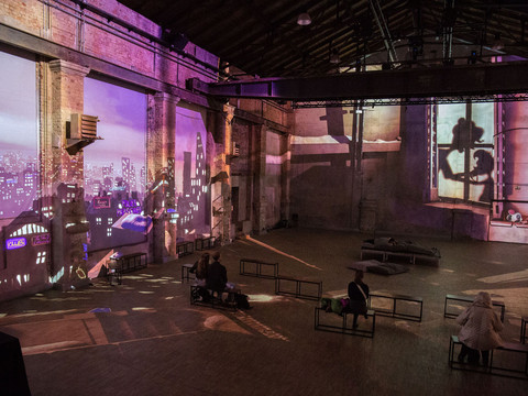Innenansicht eines historischen Industriegebäudes mit projizierten Stadtlichtern und Schatten.Interior view of a historic industrial building with projected city lights and shadows.Pohled do interiéru historické průmyslové budovy s promítanými světly a stíny města.Widok wnętrza zabytkowego budynku przemysłowego z wyświetlanymi światłami i cieniami miasta.Binnenzicht van een historisch industrieel gebouw met geprojecteerde stadslichten en schaduwen.Vista interna di un edificio industriale storico con luci e ombre della città proiettate.