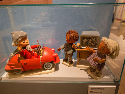 3 - Sandmännchen in Leipzig - Foto Andreas Schmidt.jpg Sandmännchen-Figuren im Auto und vor dem Fernseher, ausgestellt in einem Museum.Sandman figures in the car and in front of the television, exhibited in a museum.Postavy Sandmana v autě a před televizí, vystavené v muzeu.Postacie Sandmana w samochodzie i przed telewizorem, wystawione w muzeum.Sandmanfiguren in de auto en voor de televisie, tentoongesteld in een museum.Figure di Sandman in auto e davanti al televisore, esposte in un museo.
