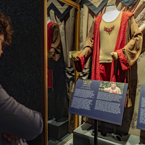 Harry Potter - The Exhibition Ein Mann betrachtet die Kostüme des Trimagischen Turniers von Harry Potter in der Harry Potter Ausstellung.A man looks at the costumes of the Harry Potter Triwizard Tournament in the Harry Potter exhibition.