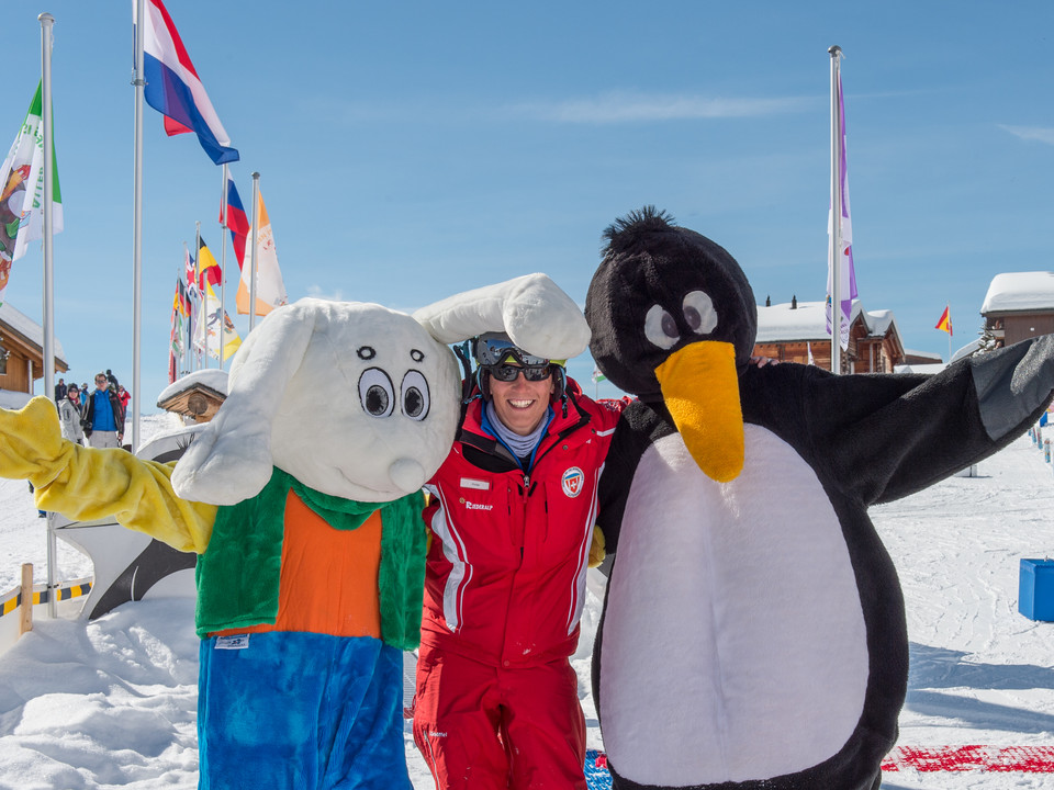 Encounter in the Snowgarden Skilehrerin steht mit Maskottchen im Snowgarden Riederalp auf dem Übungsgelände