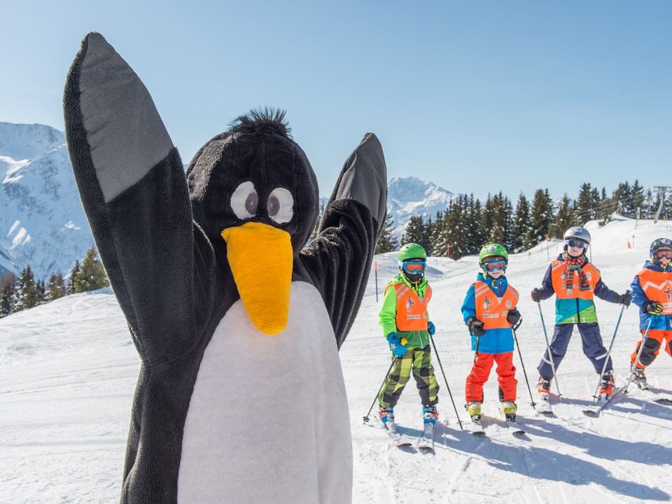 Mascots provide motivation Skilehrerin steht mit Maskottchen im Snowgarden Riederalp auf dem ÜbungsgeländeSki instructor with mascot on the practice area at Snowgarden RiederalpUne monitrice de ski se tient sur le terrain d'entraînement du Snowgarden de Riederalp avec une mascotte.