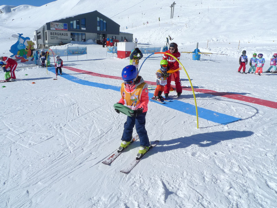 Erste Schritte auf Skiern Kind übt im Snowgarden Fiescheralp mit Unterstützung einer Skilehrerin auf SkiernChild practicing on skis in the Snowgarden Fiescheralp with the support of a ski instructorUn enfant s'entraîne sur des skis au Snowgarden Fiescheralp avec l'aide d'une monitrice de ski