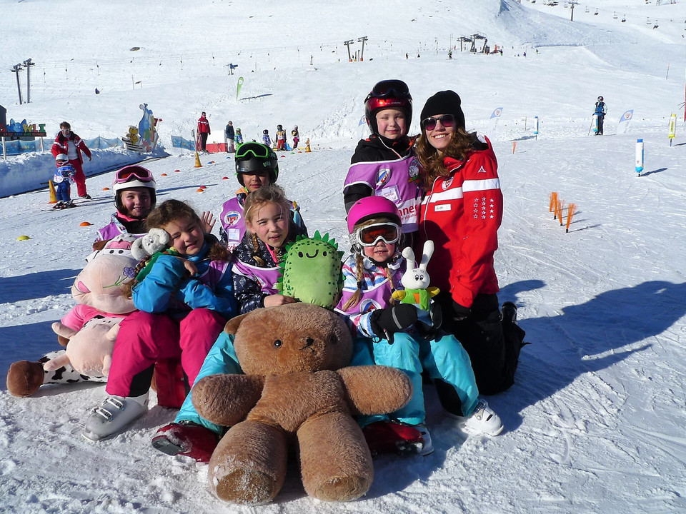 La sécurité au Snowgarden Kinder sitzen mit Skilehrerin im Snowgarden Fiescheralp und halten Plüschtiere im SchneeChildren sit with a ski instructor in the Snowgarden Fiescheralp and hold cuddly toys in the snowDes enfants sont assis avec une monitrice de ski au Snowgarden Fiescheralp et tiennent des animaux en peluche dans la neige.