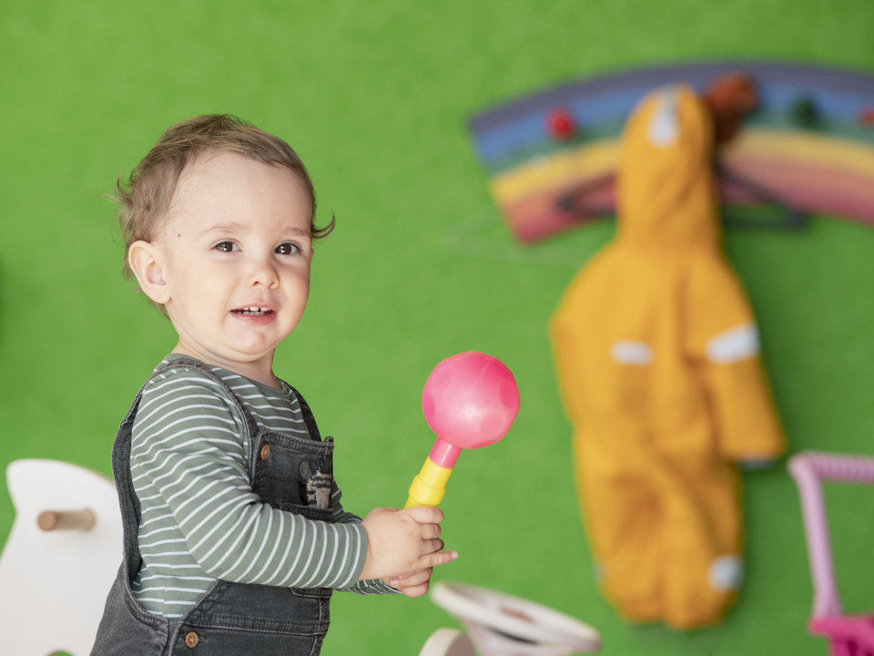 Spielerisches Lernen im Kinderhort Kind hält Spielzeug im Kinderhort Bettmeralp und spielt kreativ in geschützter UmgebungChild holds toys in the Bettmeralp day nursery and plays creatively in a protected environmentUn enfant tient un jouet dans la garderie de Bettmeralp et joue de manière créative dans un environnement protégé