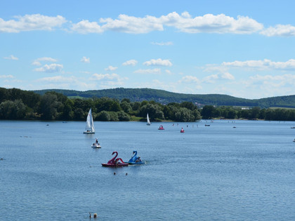 Ausblick Salzgittersee mit Höhenzug (7)_HD_16zu9.JPG Segel- und Tretboote auf dem Salzgittersee mit grünem Höhenzug und blauem Himmel im Hintergrund