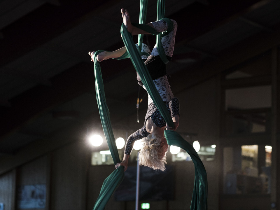 Acrobaties sur le drap vert Ein Kind hängt kopfüber eingewickelt in einem grünen Vertikaltuch bei einer Übung im Mitmachzirkus Aletsch Arena.A child hangs upside down wrapped in a green vertical cloth during an exercise in the Aletsch Arena hands-on circus.Un enfant est suspendu la tête en bas, enveloppé dans un tissu vertical vert, lors d'un exercice au cirque participatif Aletsch Arena.