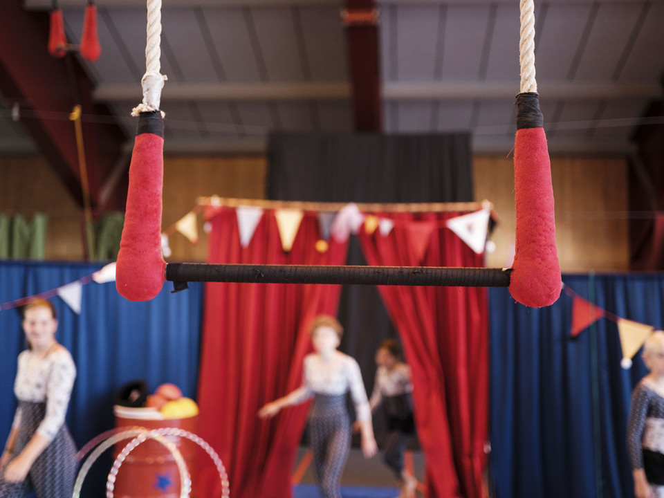 Fokus auf das Trapez Nahaufnahme einer Trapezstange, im unscharfen Hintergrund trainieren Kinder im Mitmachzirkus Aletsch Arena.Close-up of a trapeze bar, in the blurred background children are training in the Aletsch Arena hands-on circus.Gros plan sur une barre de trapèze, à l'arrière-plan flou, des enfants s'entraînent au cirque participatif Aletsch Arena.
