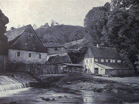 Grundmühle um 1900 Historische Aufnahme mit mehreren Häusern und Fluß im V ordergrund-