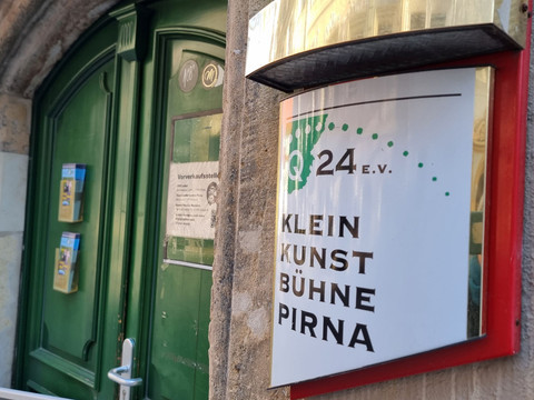 Kleinkunstbühne Q24 Pirna Eingangsschild Schild Kleinkunstbühne an Hauswand dahinter grüne Eingangstür