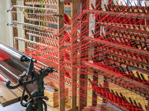Close-up van het Bramsche textielfabrieksmuseum, met weefgetouw, garens en historische textielproductietechnologie.