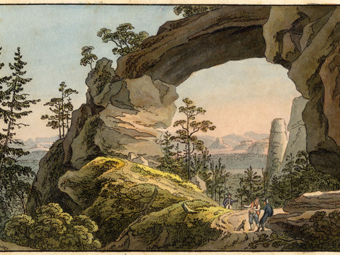 Blick durch einen großen Felsenbogen auf eine bewaldete Landschaft mit Wanderern im Vordergrund.