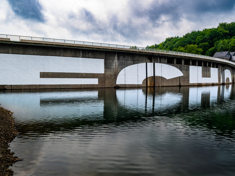Kunstinstallation ECHO Aggertalsperre mit weißen ECHO-Buchstaben auf der Staumauer und deren Spiegelung im Wasser.