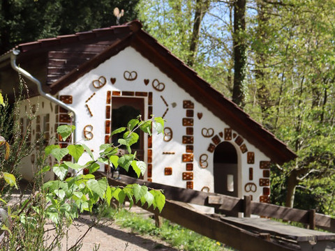 Osterzeit im Märchenwald Knusperhäuschen im Märchenwald Altenberg, dekoriert mit Brezeln und kleinen Ziegeln.
