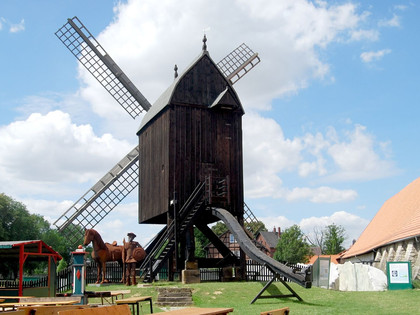 Bockwindmuehle_Salder_HD_16zu9.jpg Historische Osterlinder Bockwindmühle aus Holz an einem sonnigen Tag unter blauem Himmel.