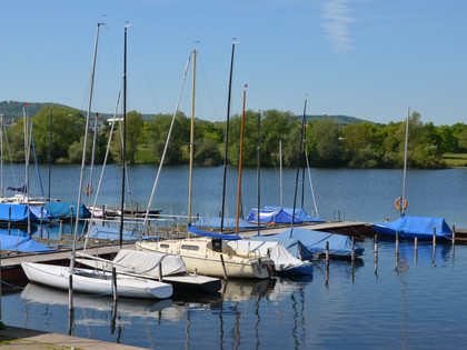 Segelhafen_Salzgittersee_HD_16zu9.JPG Segelboote am Holzsteg auf dem Salzgittersee vor grünem Ufer unter blauem Himmel.