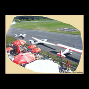 ab_cafeamraeuschenberg_terrasse.jpg Sonnenterrasse mit Sonnenschirmen und Flugzeuge in Parkposition