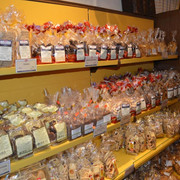 Keksgalerie im Schulze Ladencafé, Borgholzhausen Verschiedene Sorten von Keksen in durchsichtigen Tüten auf gelben Regalen in einem Ladencafé.