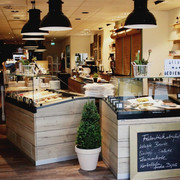 schmeckwerk-k-che Tresen mit Auslagen in Holzoptik im Gastraum