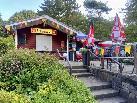 Freizeitpark Lindlar Kiosk Bahn19 mit Außenterrasse, Sonnenschirmen und Blumen im Freizeitpark Lindlar