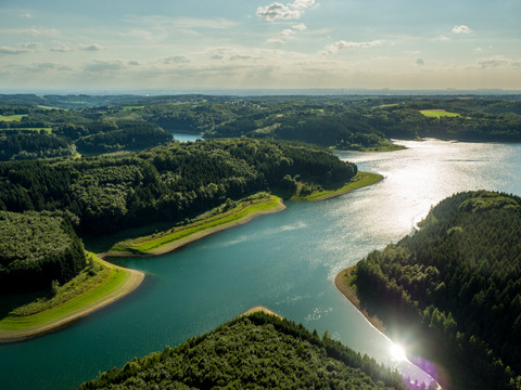 Große Dhünn- Talsperre Ein weitläufiger Stausee inmitten bewaldeter Hügel unter einem leicht bewölkten Himmel.