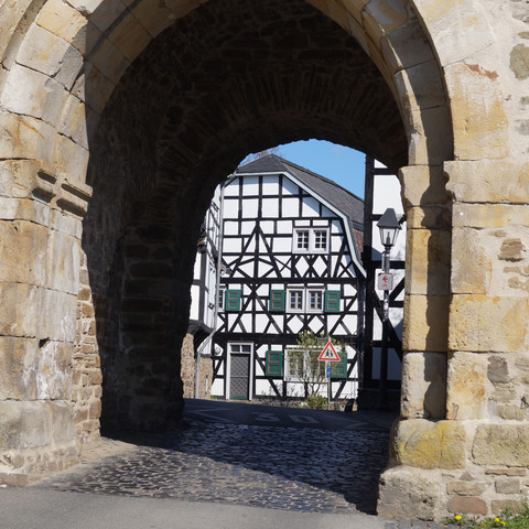 Katharinenturm in Stadt Blankenberg Fachwerkhaus hinter historischem Steintor in Hennef bei sonnigem Wetter.