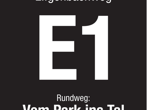 Markierungszeichen E1 Hinweisschild für Wanderweg Eifgenbachweg E1, Rundweg "Vom Park ins Tal", auf schwarzem Grund.