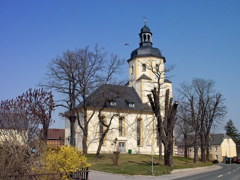 Barockkirche in Triebes mit markantem Zwiebelturm umgeben von kahlen Bäumen.Baroque church in Triebes with a striking onion dome surrounded by bare trees.Barokní kostel v Triebesu s nápadnou cibulovou kopulí obklopený holými stromy.Barokowy kościół w Triebes z imponującą cebulową kopułą otoczoną nagimi drzewami.Barokke kerk in Triebes met een opvallende uienkoepel omringd door kale bomen.Chiesa barocca di Triebes con una suggestiva cupola a cipolla circondata da alberi spogli.