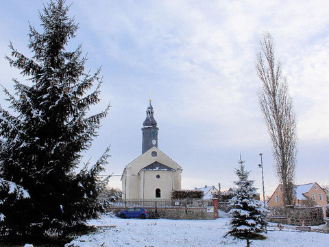 Eine schneebedeckte Kirche neben schneebedeckten Bäumen im Winter.A snow-covered church next to snow-covered trees in winter.Zasněžený kostel vedle zasněžených stromů v zimě.Ośnieżony kościół obok ośnieżonych drzew zimą.Een besneeuwde kerk naast besneeuwde bomen in de winter.Una chiesa innevata accanto ad alberi innevati in inverno.