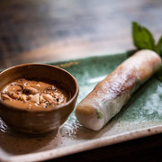 Chum Chay Sommerrolle auf einem grünen Teller mit Erdnusssoße Summer roll on a green plate with peanut butter dip