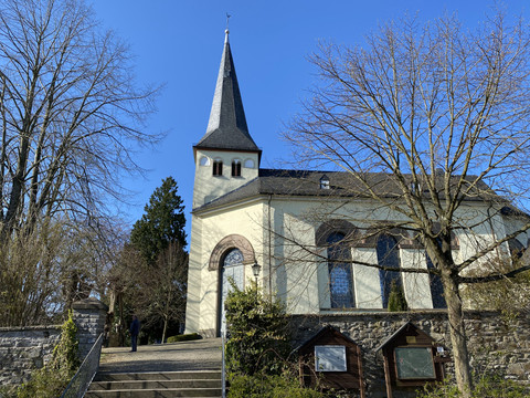 Kirche in Hohkeppel St. Severin Kirche in Lindlar, von vorne mit blauem Himmel und treppenartigem Zugang.