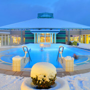 Driburger Therme im Winter Ein Spa-Becken der Driburger Therme ist umgeben von Schnee, unter einem beleuchteten Winterhimmel.