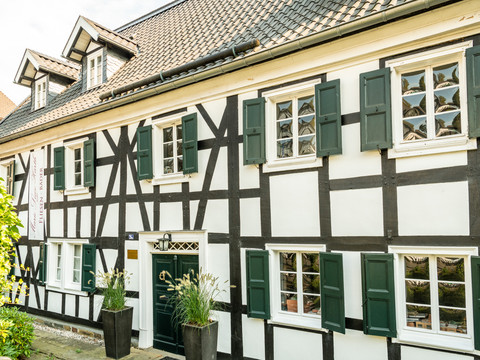 Altstadt Ruppichteroth Fachwerkhaus mit grünen Fensterläden und Blumen vor der Tür im malerischen Ruppichteroth.