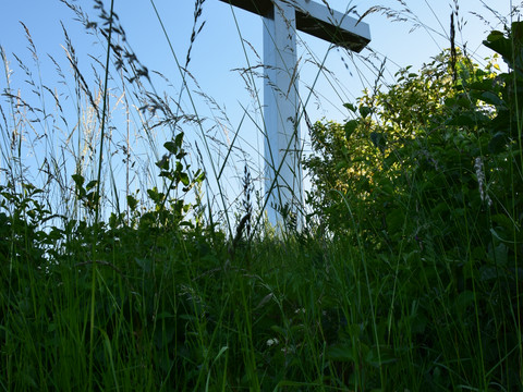 Barbarakreuz <p>Ein großes Kreuz steht auf einer grünen Wiese unter einem klaren blauen Himmel.</p>